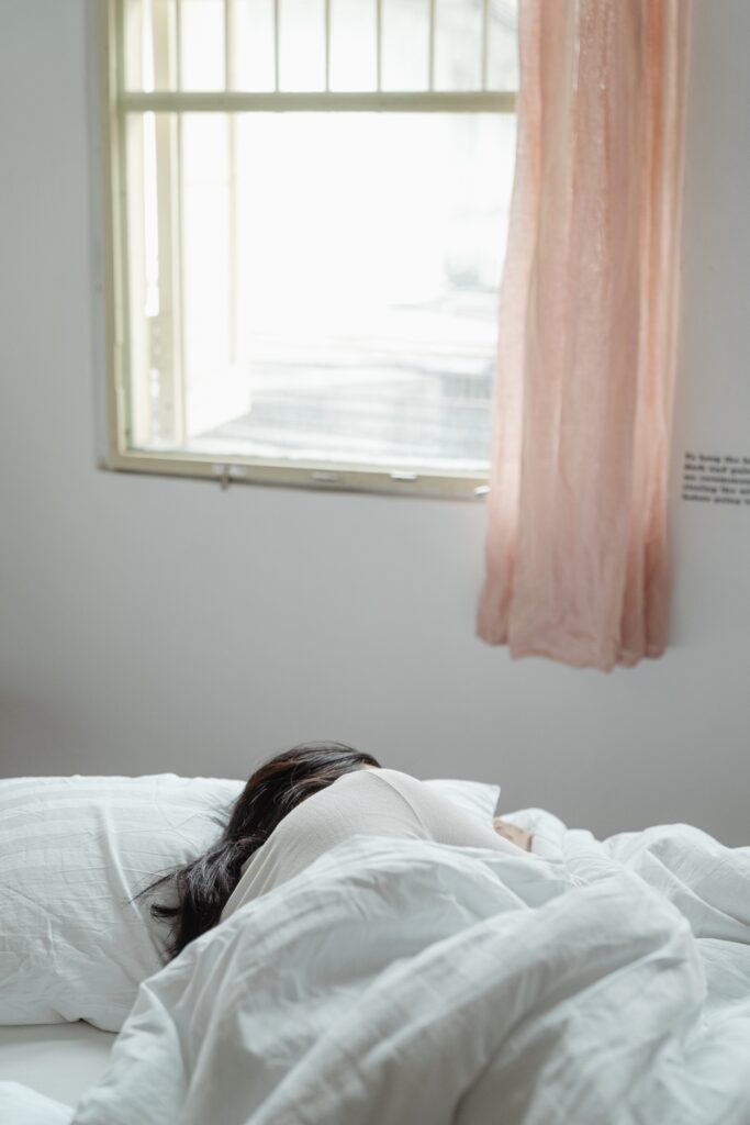 woman lying on bed near window image