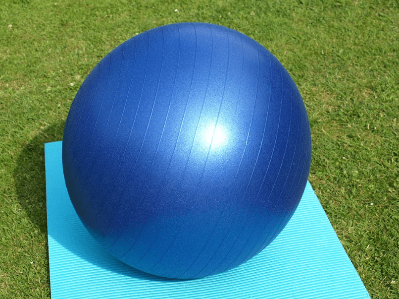 a blue exercise ball on a yoga mat