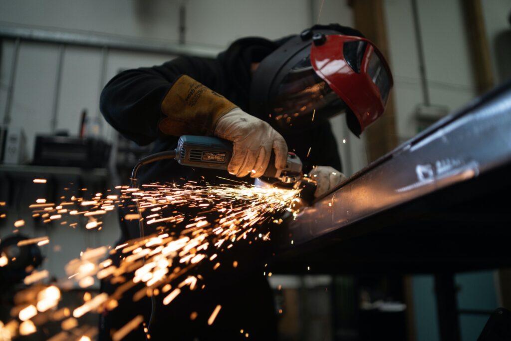 a man doing a metal work in a manufacturing company image
