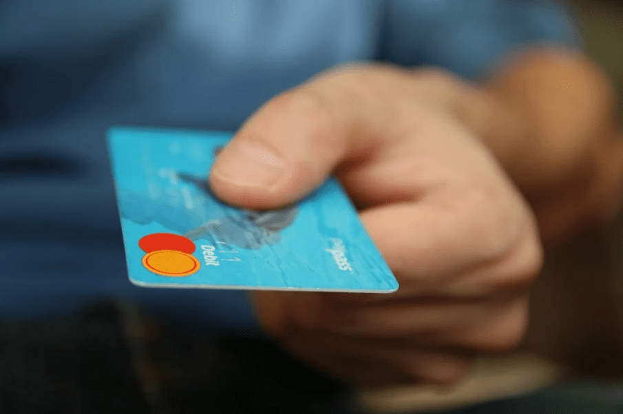 a person holding a blue credit card