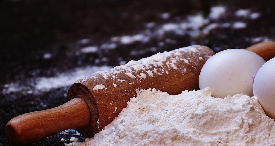 rolling pin next to eggs and flour