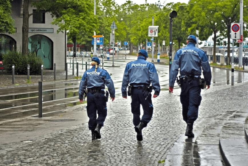 3 police officers walking in the rain.