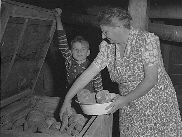 A black-and-white photo of a mother and child storing food 