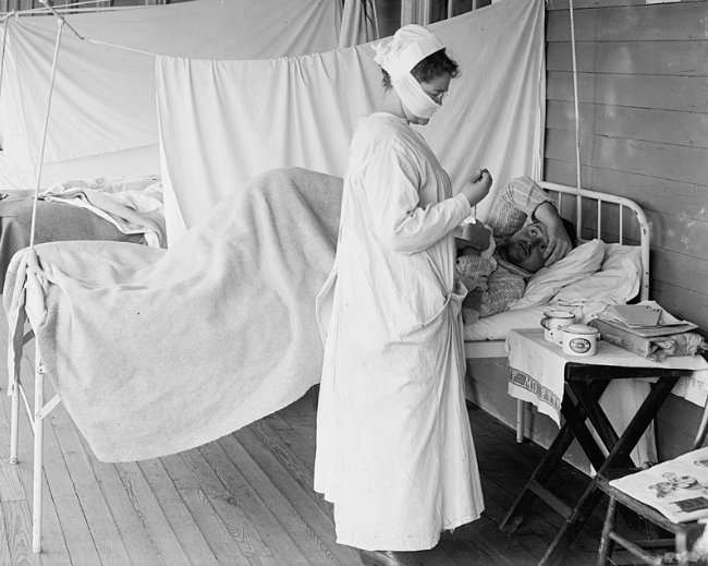 Image showing a nurse wears a cloth mask while treating a patient