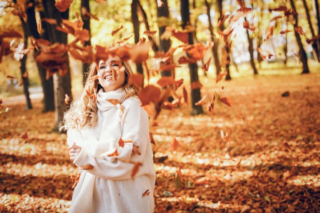 Picture-of-a-happy-woman-in-autun-leaves.