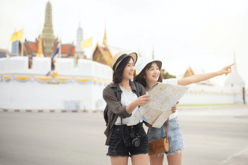 Woman pointing out the way to a tourist holding a map.