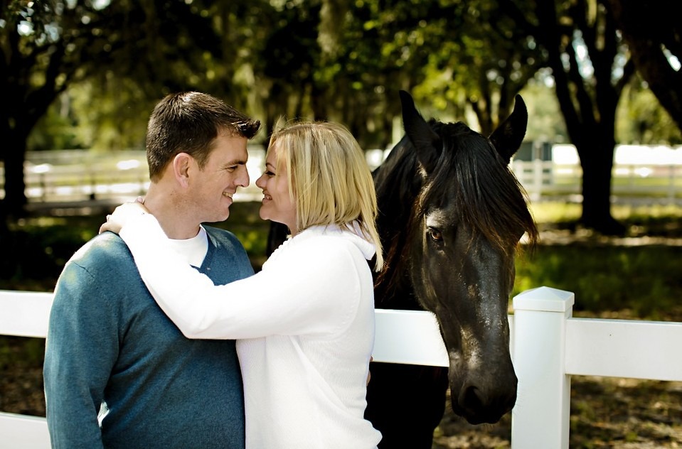 a couple in front of a horse