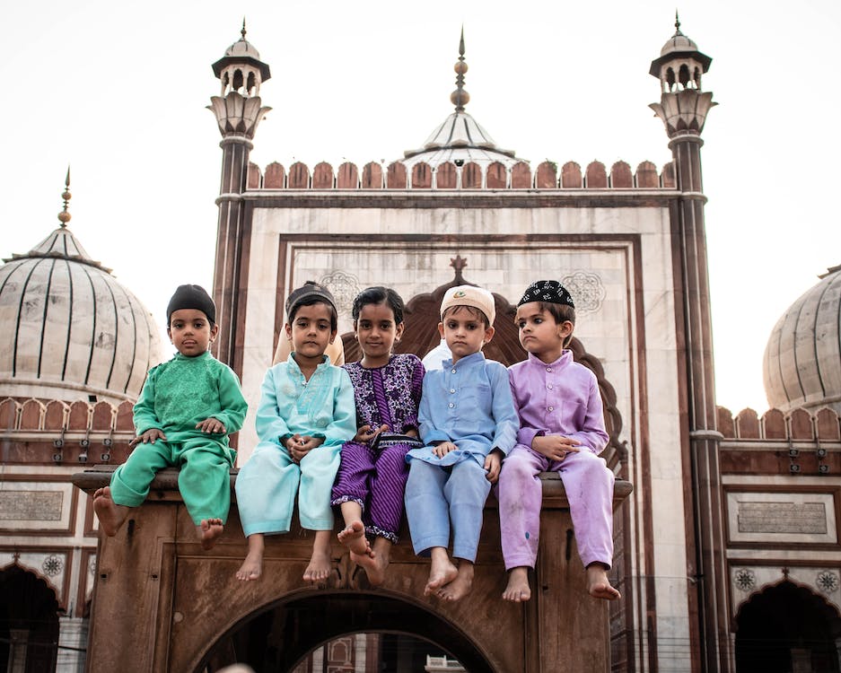 a group of Muslim kids sitting in front of the Jama masjid Delhi, india