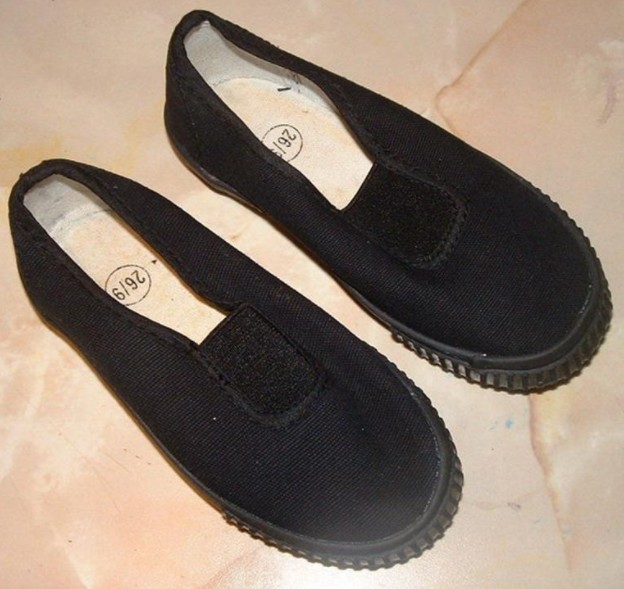 a pair of traditional black plimsolls
