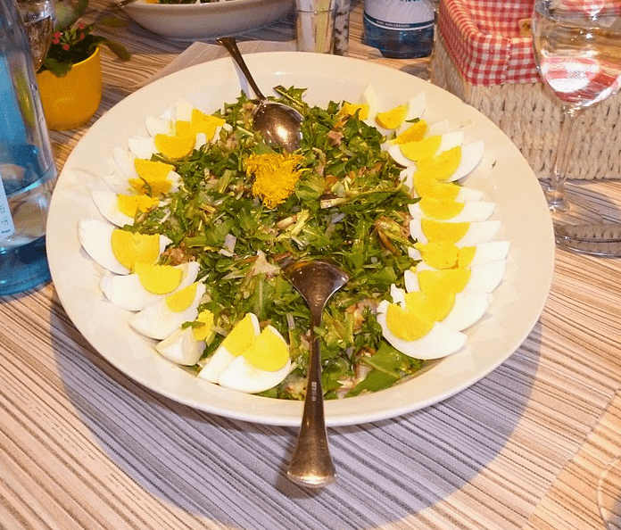 a plate of dandelion salad with hard boiled eggs