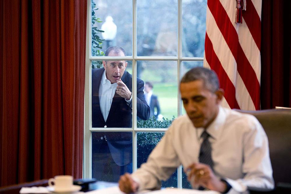 Jerry Seinfeld tapping on the Oval Office windows of the White House with President Barack Obama in 2015
