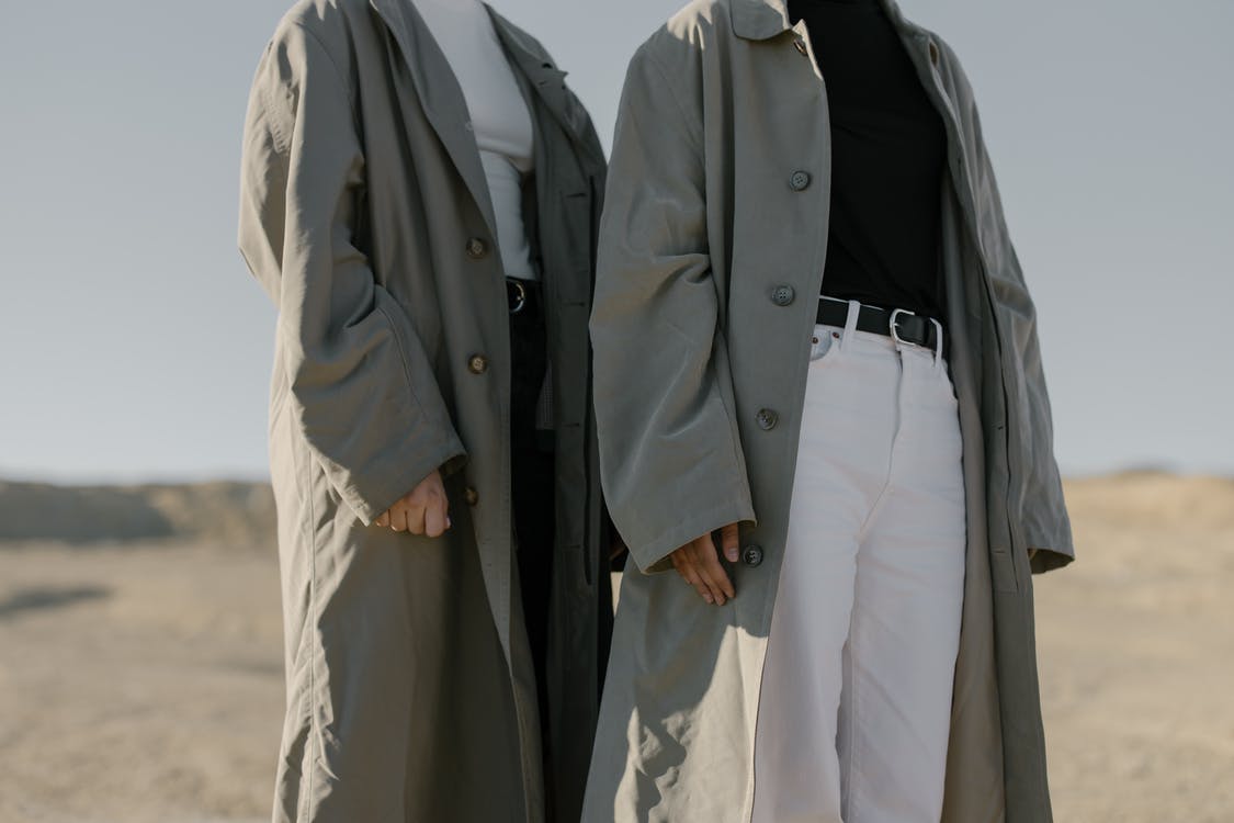men in white pants and grey trench coats. 