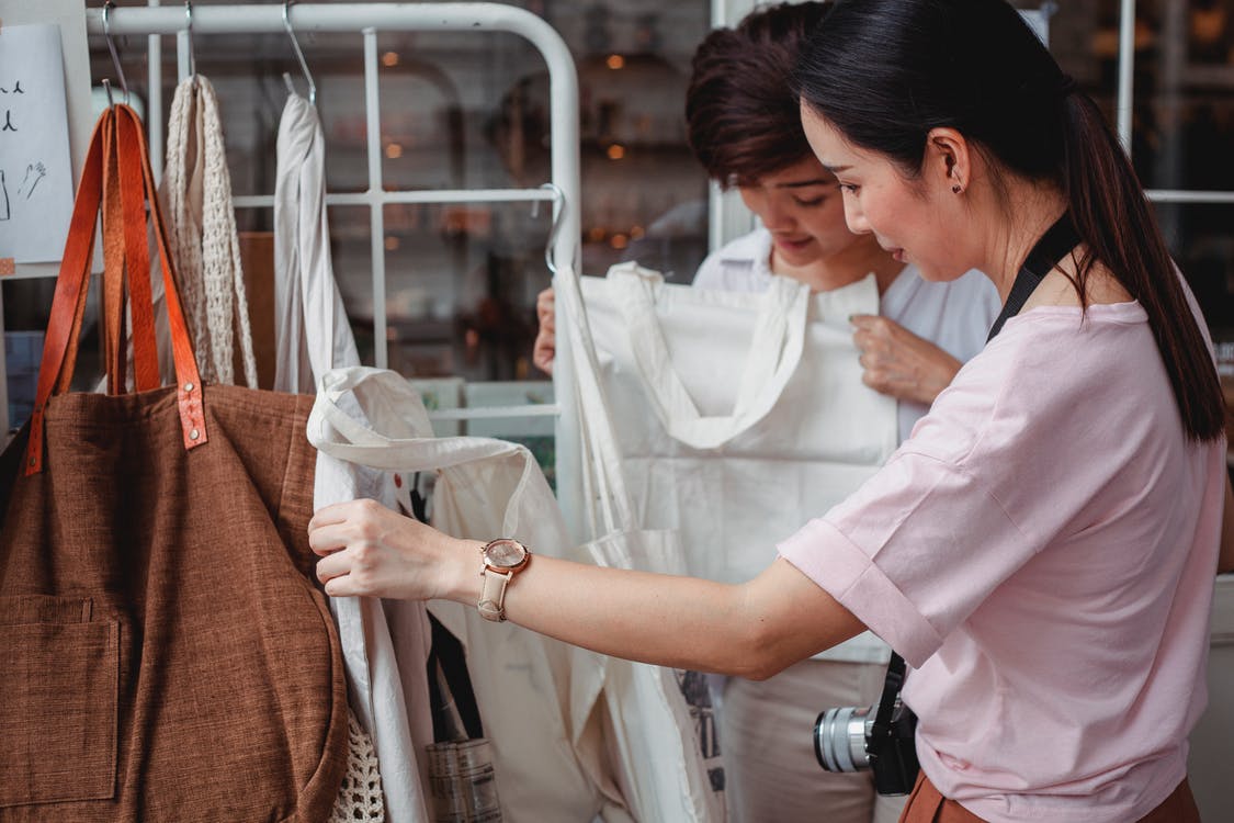 women choosing cotton bags in a fashion boutique.