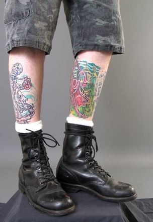 A man wearing tatoos and combat boots