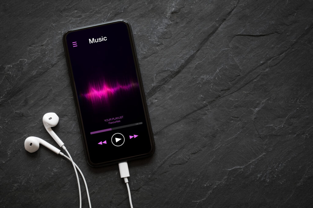 An image of a Music player on mobile phone with earphones on black background