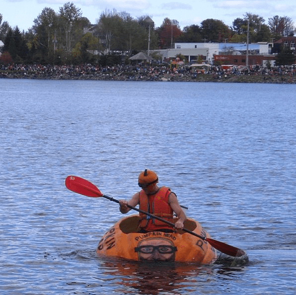 a man kayaking using a giant pumpkin