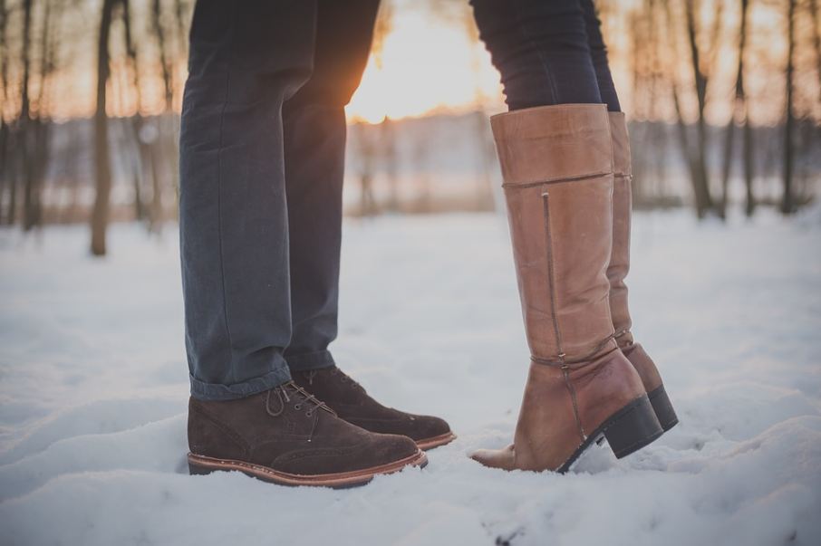 boots of a male and female couple in the snow