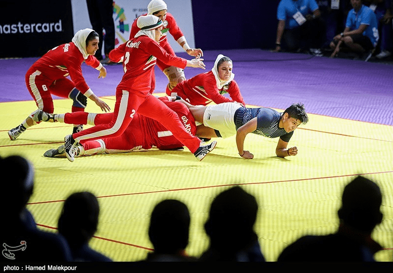 raider being prevented by the opposing team in a game of kabaddi