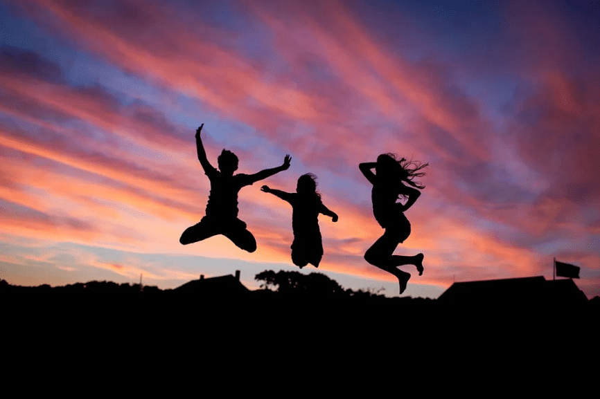 silhouette of three girls jumping