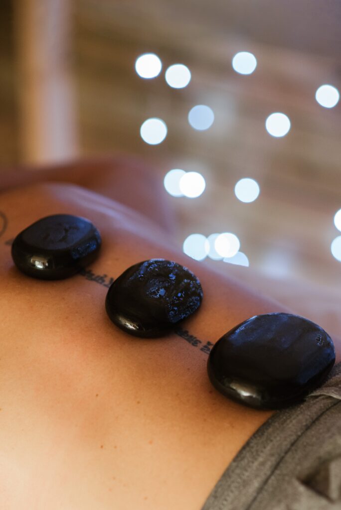 person with hot stones on back during the massage procedure image