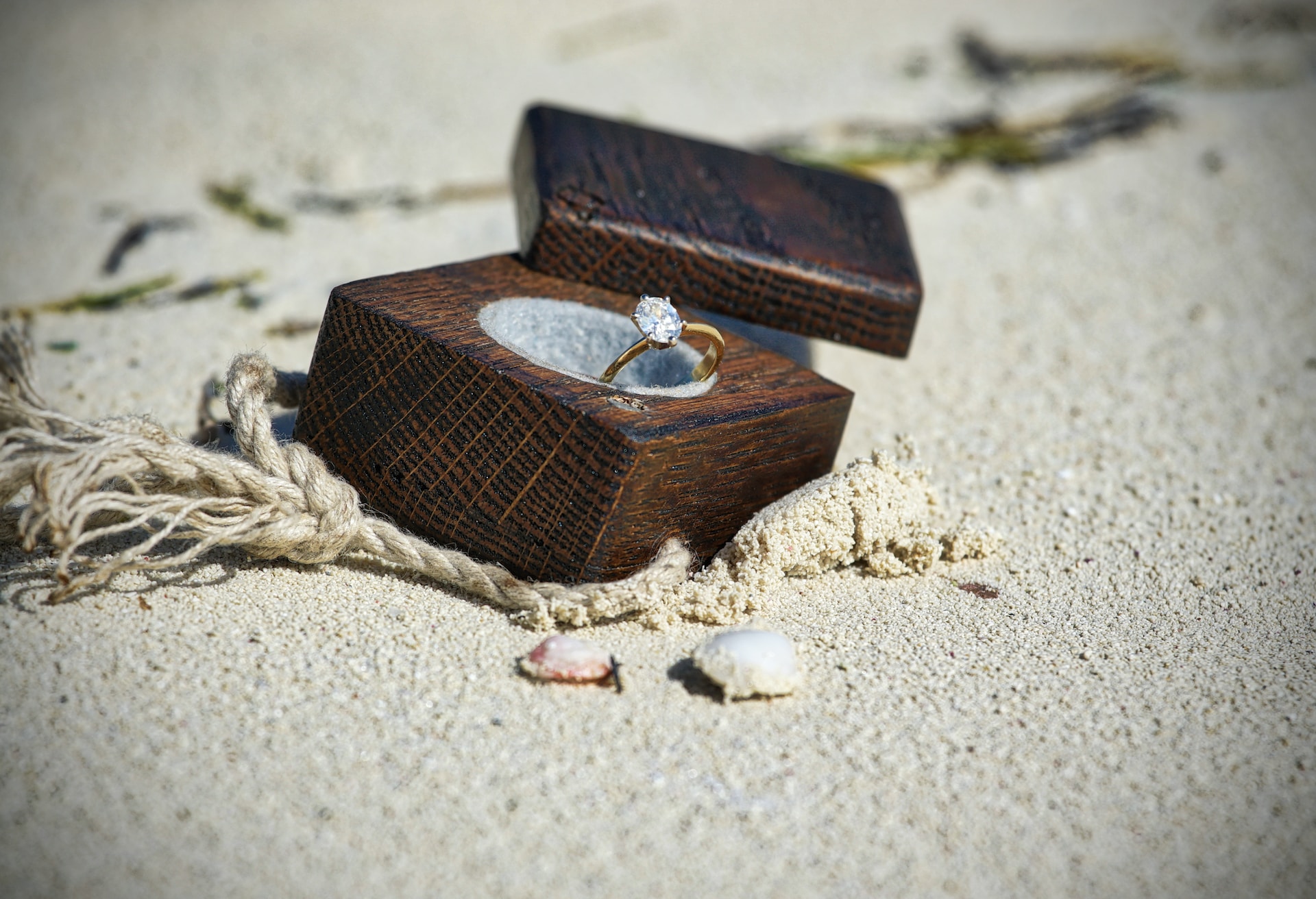 ring inside a box placed in white sand