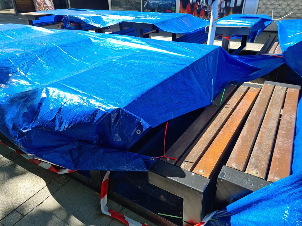 Tarps covering outdoor furniture pieces