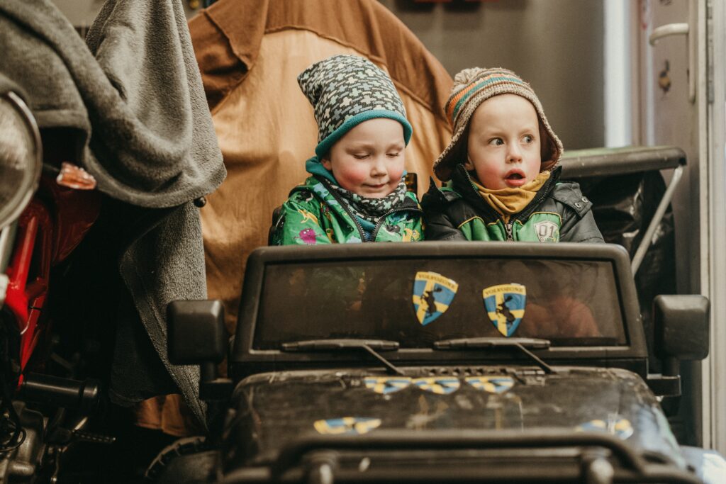 two kids riding a kiddie car image