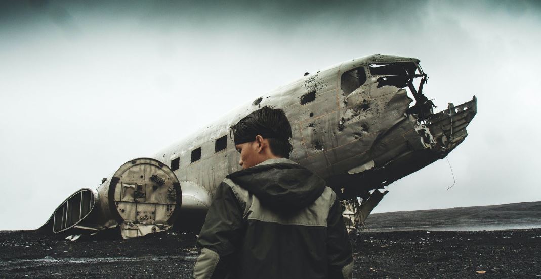 A man in front of a wrecked plane