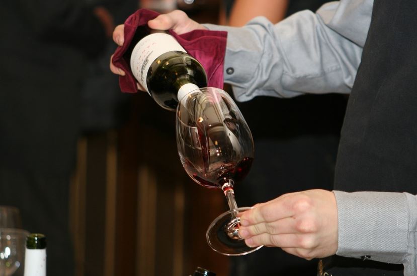 person pouring wine in a glass