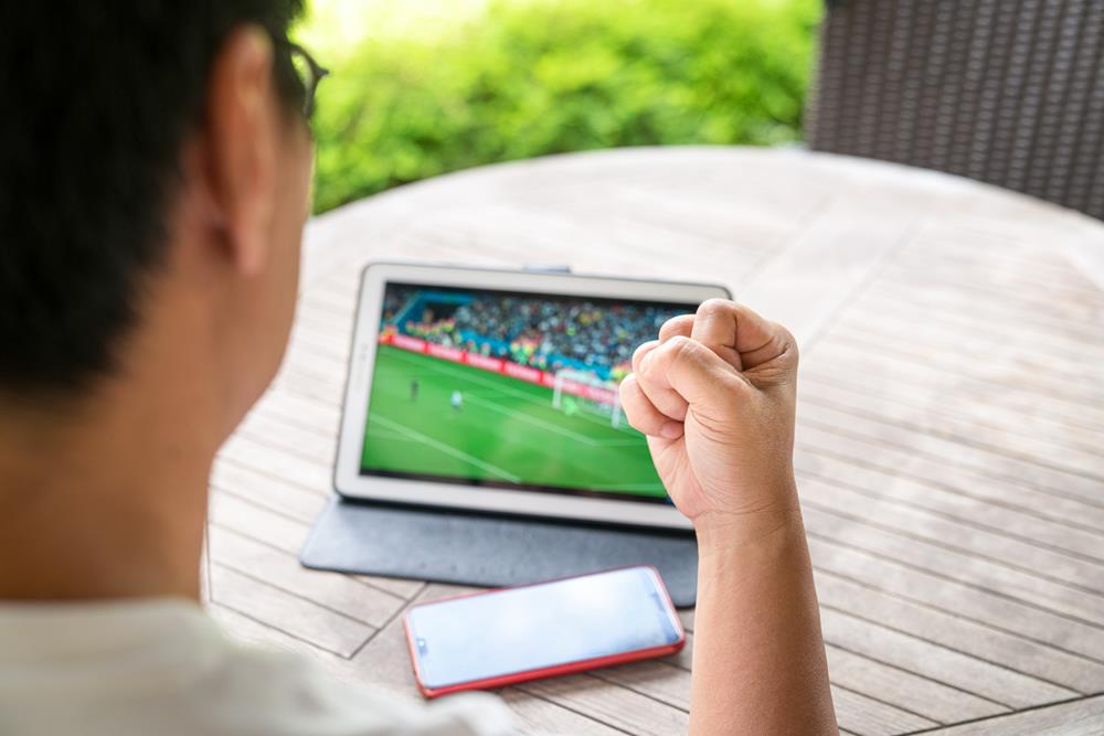 Person watching a soccer game on a tablet