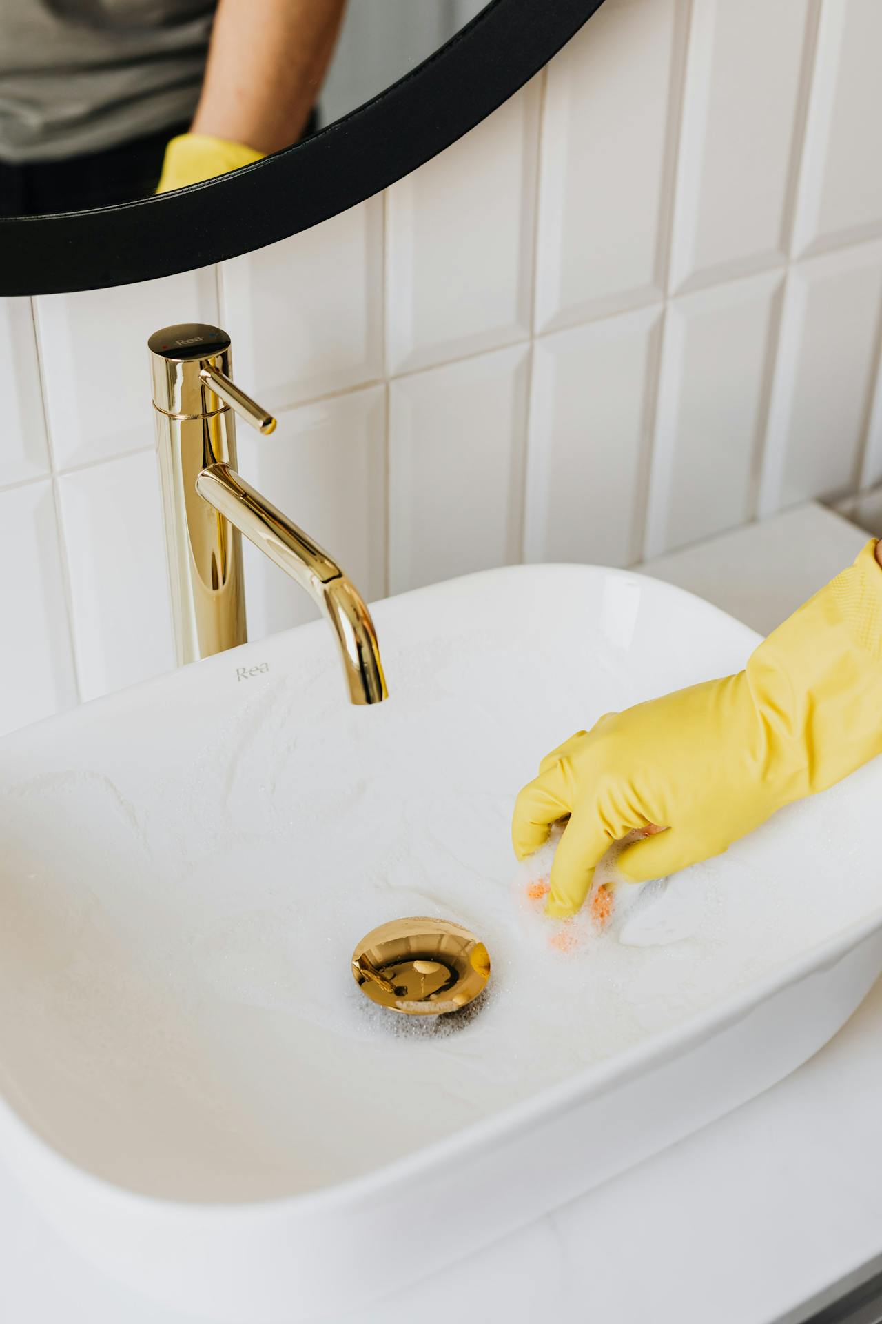 sink being cleaned by maid in a serviced apartment
