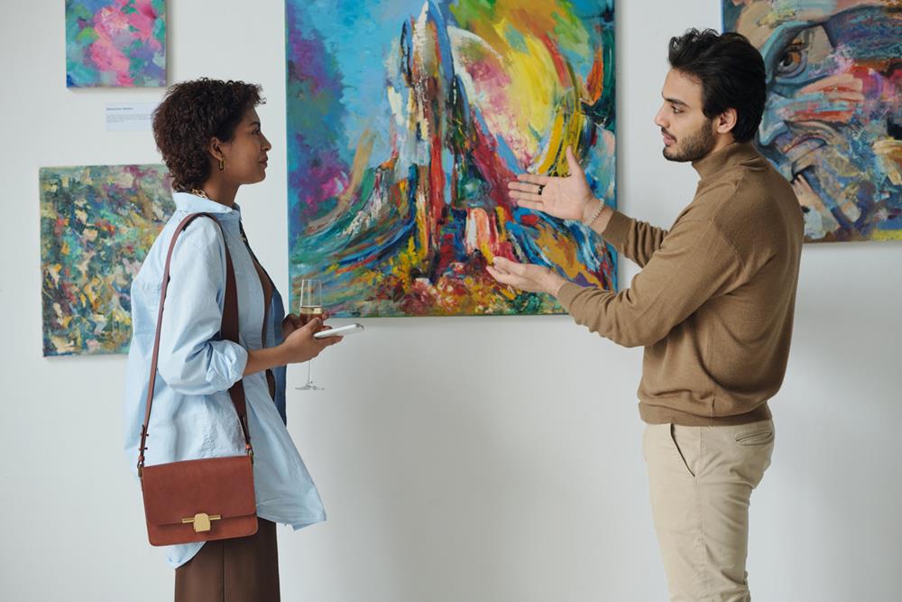 Man discussing a painting with a woman