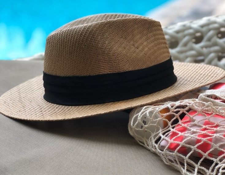 beige-and-black-hat-near-swimming-pool