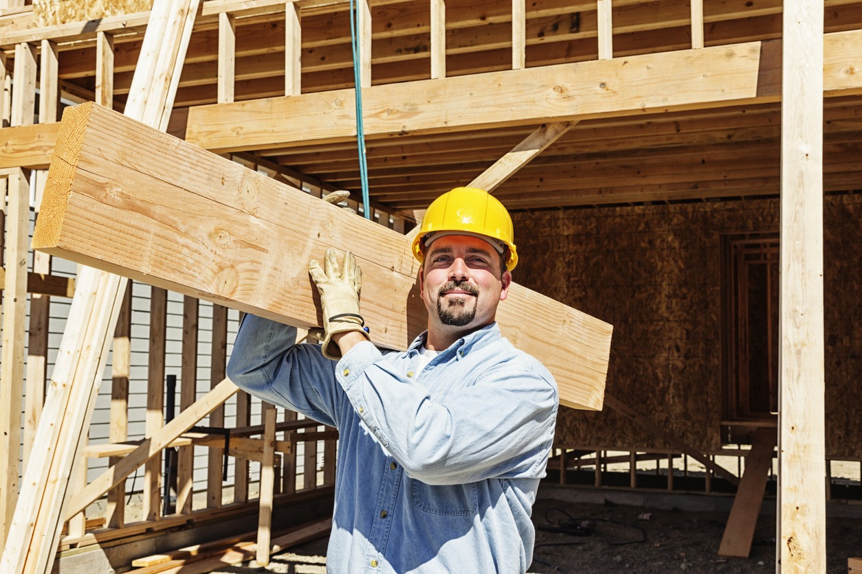 Construction Worker Carrying Wood Beam