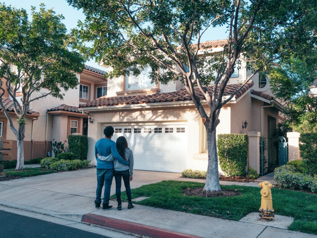 couple standing in front of their house image