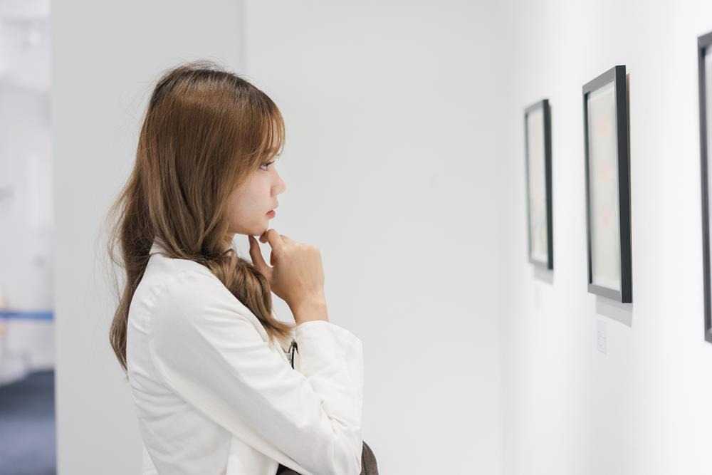 Woman looking at photographs in an art gallery