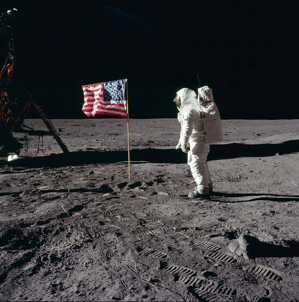 Astronaut Buzz Aldrin, Lunar Module pilot of the first lunar landing mission, poses for a photograph beside the deployed United States flag during an Apollo 11 Extravehicular Activity (EVA) on the lunar surface