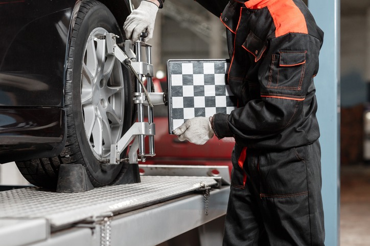 auto mechanic sets the car for diagnostics and configuration. Wheel alignment equipment on a car wheel in a repair station