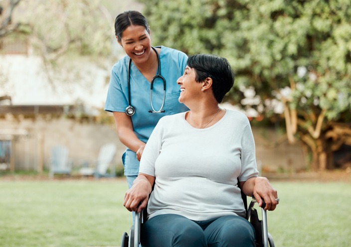 Shot of a young nurse caring for an older woman in a wheelchair