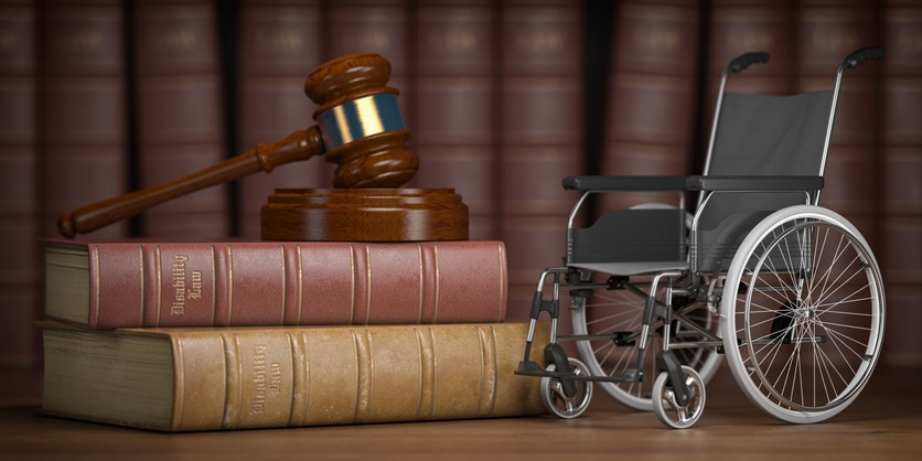 Disability law and social services for disabled people concept. Wheelchair and gavel.