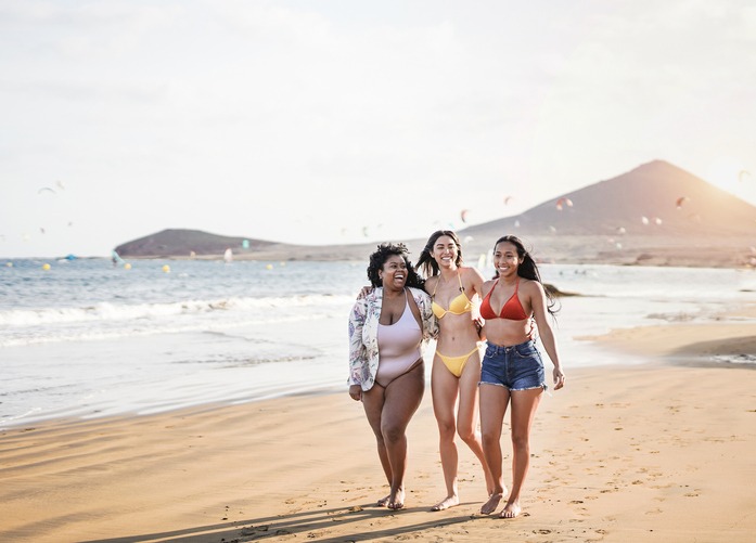 Beautiful latin women with different bodys and skin color walking on the beach - Millennial girls having fun together in summer vacation