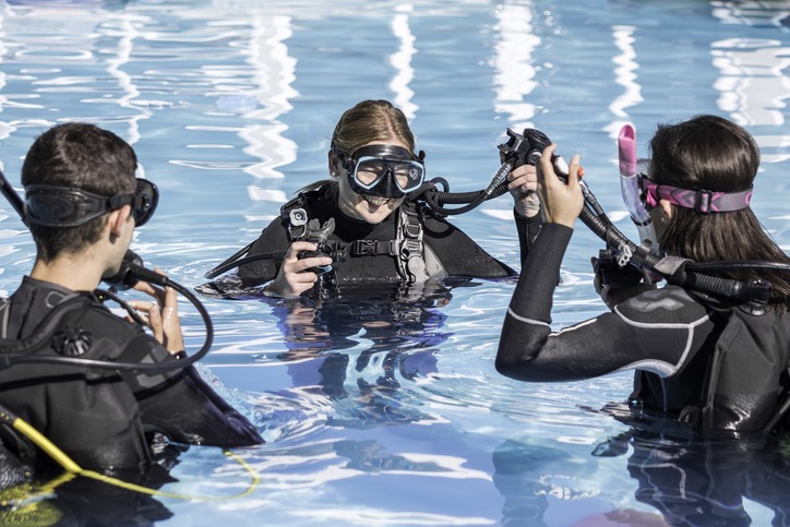 Scuba dive training in the pool with a smiling instructor