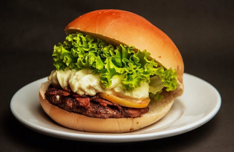 burger with lettuce and cheese on a white plate
