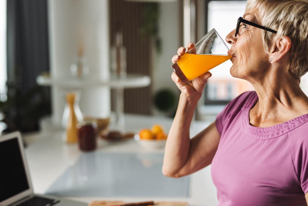 Elderly woman drinking orange juice