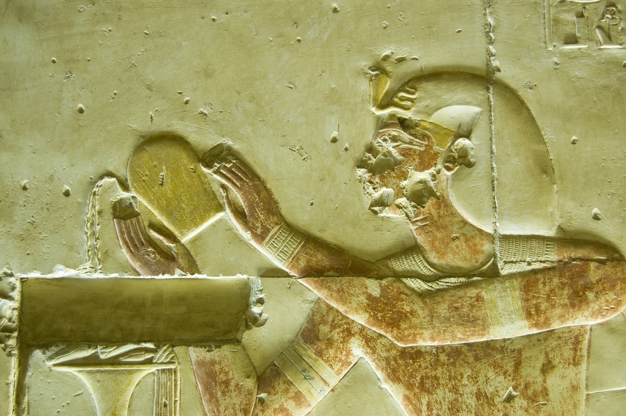 Ancient Egyptian bas relief showing the Pharaoh Seti I pouring a liquid, probably wine