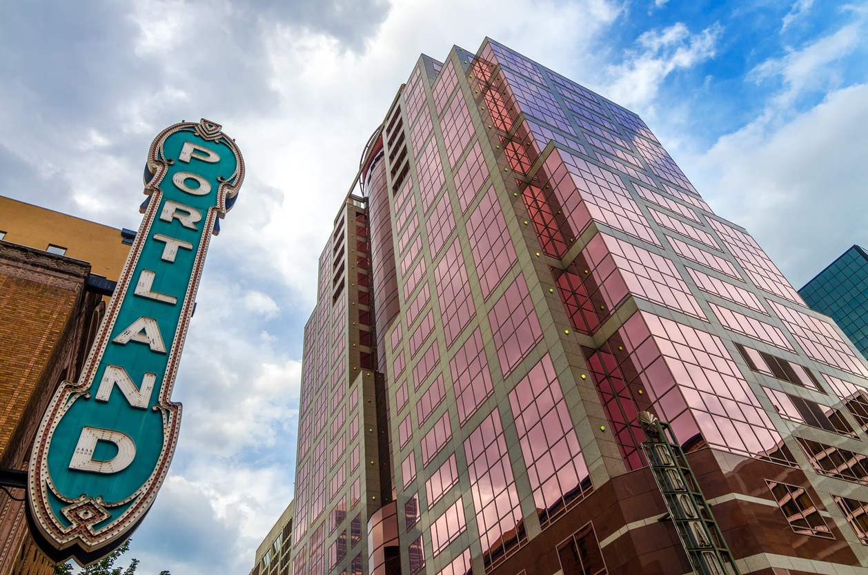 Iconic Portland sign with pink skyscraper rising next to it