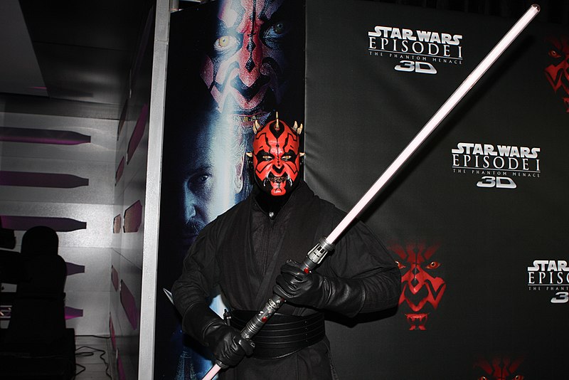 a Star Wars fan wearing costume in front of a Star Wars photo background