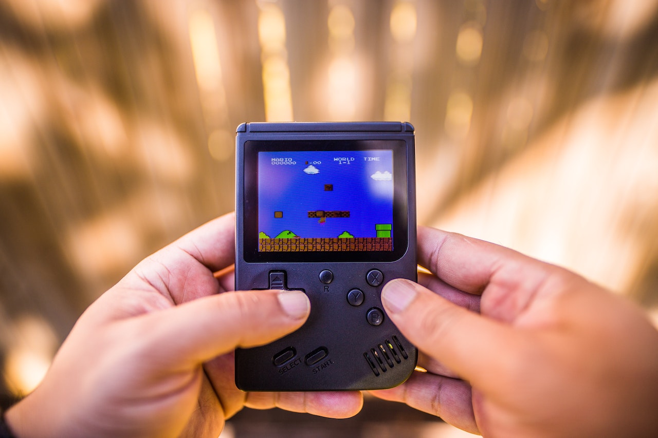 a person playing Super Mario Land in a black Game Boy