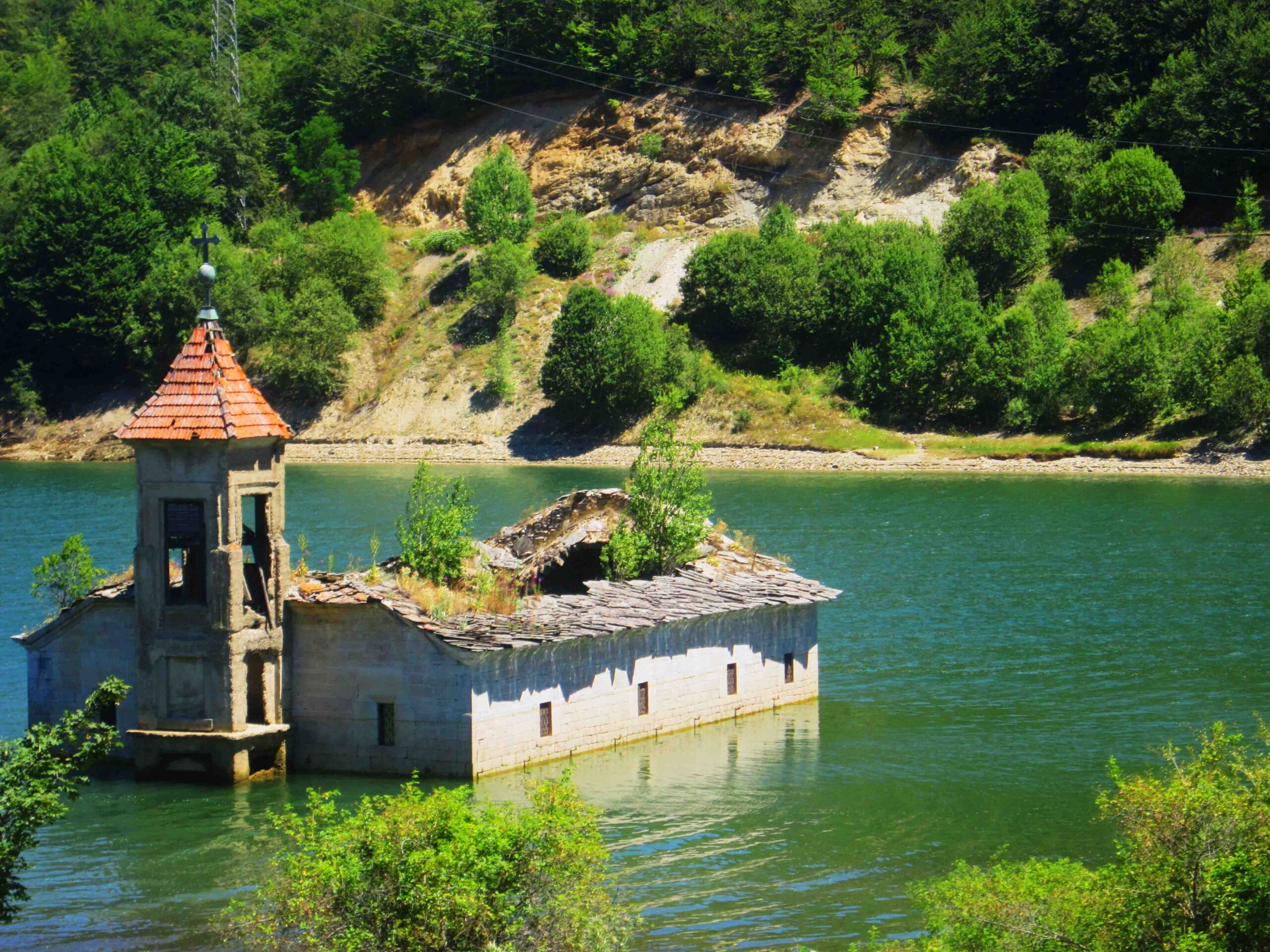 a photo of a submerged church in the middle of the lake