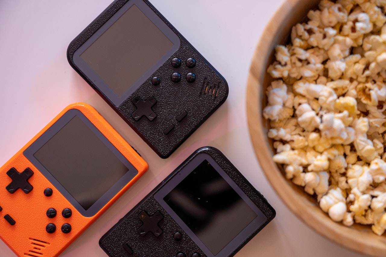 black and orange game boys next to a bowl of popcorn
